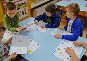 Dzieci ogladają książeczki edukacyjne do realizacji programu Dzieciaki-Mleczaki